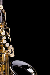 A black saxophone with gold plated keys on a black background