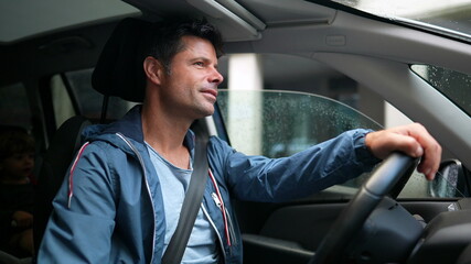 Happy driver holding steering wheel driving in city