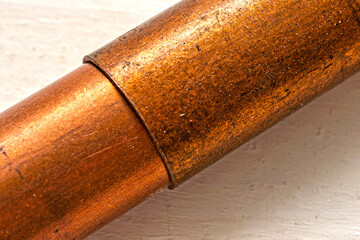The articulation of two copper pipes in close-up