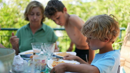Family eating lunch outside gathered together during meal