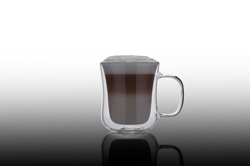 Double glass cappuccino cup on the mirror. Glass cup of coffee on glass. Double glass cup isolated. Modern glass cappuccino cup.