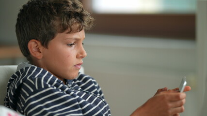 Child using tablet device. Young boy holding screen