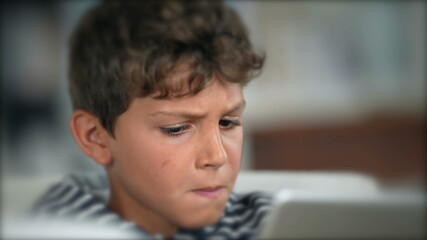 Obraz premium Child surprised reaction holding tablet. Boy WOW face emotion