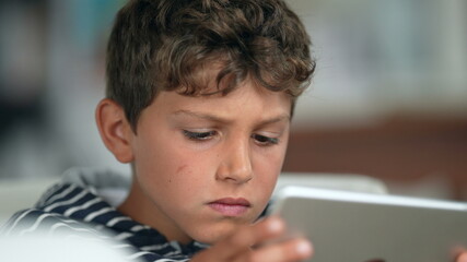 Obraz premium Child amazed reaction to content online holding tablet