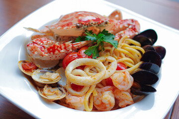 Seafood spaghetti with crab, mussels, squid rings, shrimps and tomato sauce