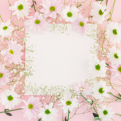 Creative pastel spring arrangement made of flowers and white canvas on a pink background. Minimal floral concept with copy space. Wedding, Easter or Mother's Day inspiration.