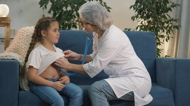 Pediatrician doctor examines child with stethoscope in clinic. Vaccination of child against coronavirus.doctor examines child before vaccination. pediatrician listens to child's lungs wit stethoscope.