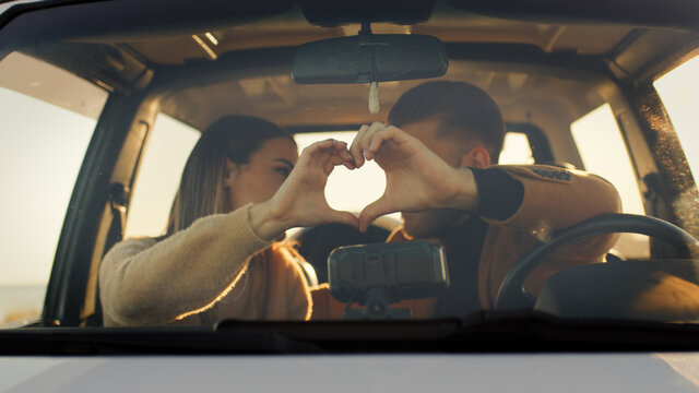 Coppia fa simbolo del cuore per San Valentino in macchina