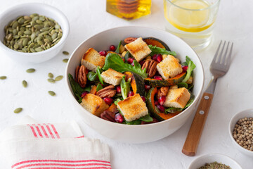 Salad with pumpkin, pomegranate, pecans and croutons. Healthy eating. Vegetarian food.