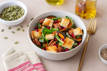 Salad with pumpkin, pomegranate, pecans and croutons. Healthy eating. Vegetarian food.