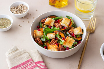 Salad with pumpkin, pomegranate, pecans and croutons. Healthy eating. Vegetarian food.