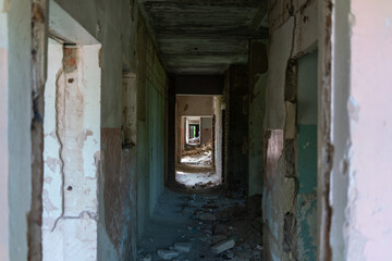 Abandoned kindergarten without children. An empty long corridor with traces of destruction and desolation in complete isolation