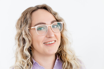 Obraz premium Portrait of a successful happy business woman in modern glasses on a light background of a minimalistic office. Curly blonde hair.