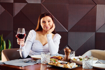 Woman with wine and food. Indoors of new modern luxury restaurant