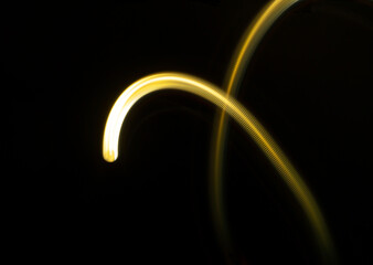 futuristic light painting in golden white textured curved line shape against black