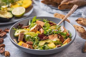 Baked salmon, mango and avocado salad with pecan nuts.