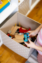 Children pull out wooden rails from a toy box. Educational toys for young children.
