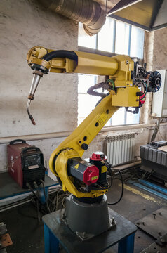 A welding robot in a production room of a mechanical plant. The picture was taken in Russia