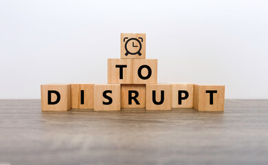 "DISRUPT" word on woodblocks include "Clock" symbol meaning "Time to disrupt" concept 