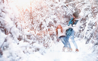 Young family for a walk. Mom and daughter are walking in a winter park.