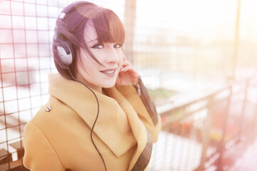 Fototapeta na wymiar Girl in headphones listening to music outdoors