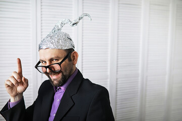 Bearded funny man in a cap of aluminum foil. Concept art phobias.Conspiracy theory. Conspiracy....