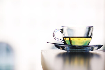 Hot steaming green tea in a cup on a rustic background