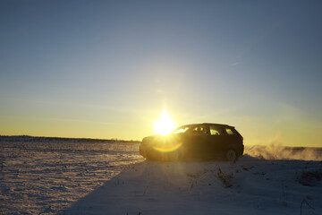 Fototapeta na wymiar Car in the field in winter. Off-road winter snow drifts. Extreme sport, entertainment.