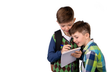 isolate. one boy writes in a notebook, and another boy looks at what he wrote