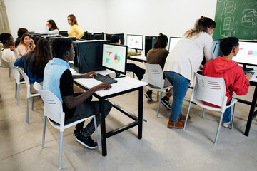 Young students doing computer class at school - Focus on african guy hand