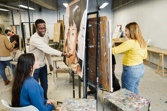 Multiracial students painting inside art room class at university - Focus on african guy face