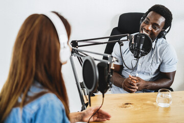 Hosts having podcast session together - African speaker making an interview during live stream - Main focus on microphone