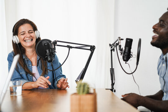 Multiracial hosts streaming podcast together at home studio - Focus on woman face