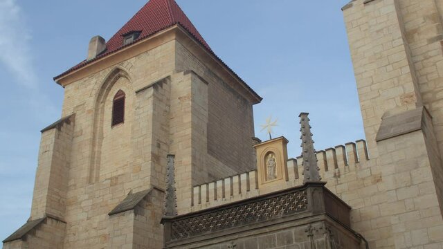 Facade of a building with a tower. There is a star on the frame of the statuette. The architectural solution of the old years. Blue sky.