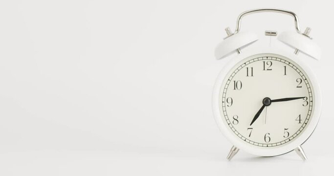 Time lapse White alarm clock shows the time at 7 o'clock. The clock shows the elapsed time on the white background.