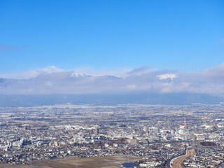 1月（冬）、高台から望む松本の街並みと、雲がかかった北アルプス 長野県松本市
