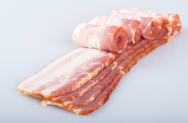 Obraz premium Rolls of thin fresh bacon, isolated on a white background