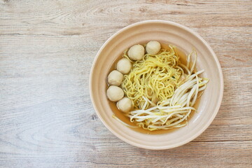 boiled Chinese yellow egg noodles with pork meatball and bean sprout in soup on bowl