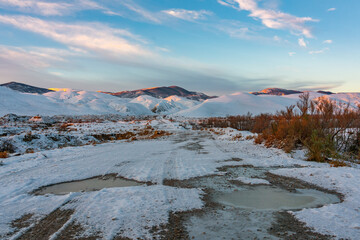 Dirt road to mountains in winter season