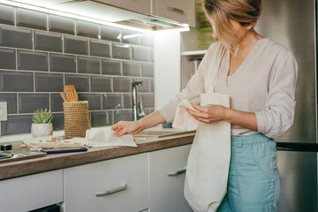 Young woman taking reusable cotton bags for shopping