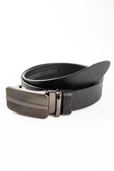 Fastened fashionable men's leather belt with dark matted metal buckle isolated on white background.