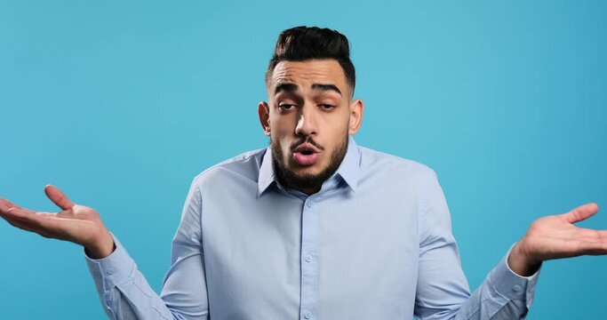 Portrait of clueless unaware man looking doubtful over blue background