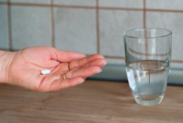 Woman hand holds a pill