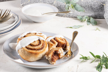 Cinnamon rolls or cinnabon  with icing for Christmas. Homemade traditional winter festive dessert buns. Pastry food for breakfast on white background