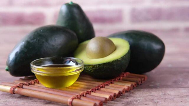 oil and slice of avocado on wooden table 