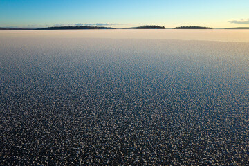Frozen lake surface in Sweden, Hoar frost covered dark blue ice of frozen Malaren lake, Twilight winter short day in Scandinavia, Vasteras, Winter nature background