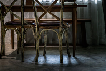 Two old wooden vintage chairs standing in an empty room near the window. Space for text, No focus, specifically.