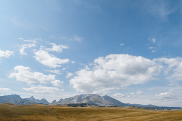Fototapeta na wymiar High mountain range over a valley against a blue sky in Durmitor National Park