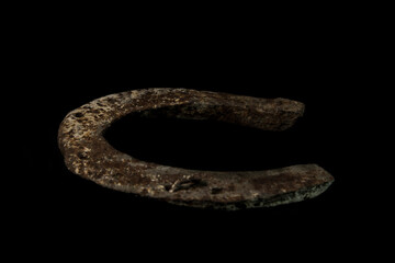 Old used rusty horseshoe on black background, copy space