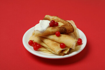 Concept of tasty food with crepes on red background